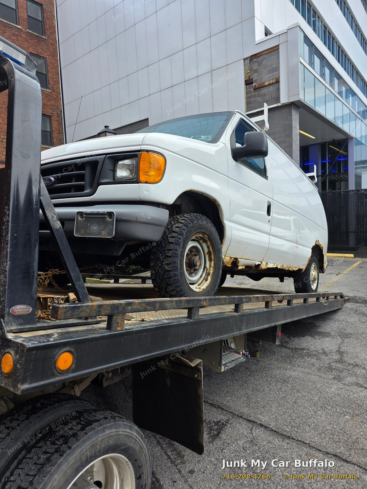 Rusted white work van loaded for junk vehicle removal